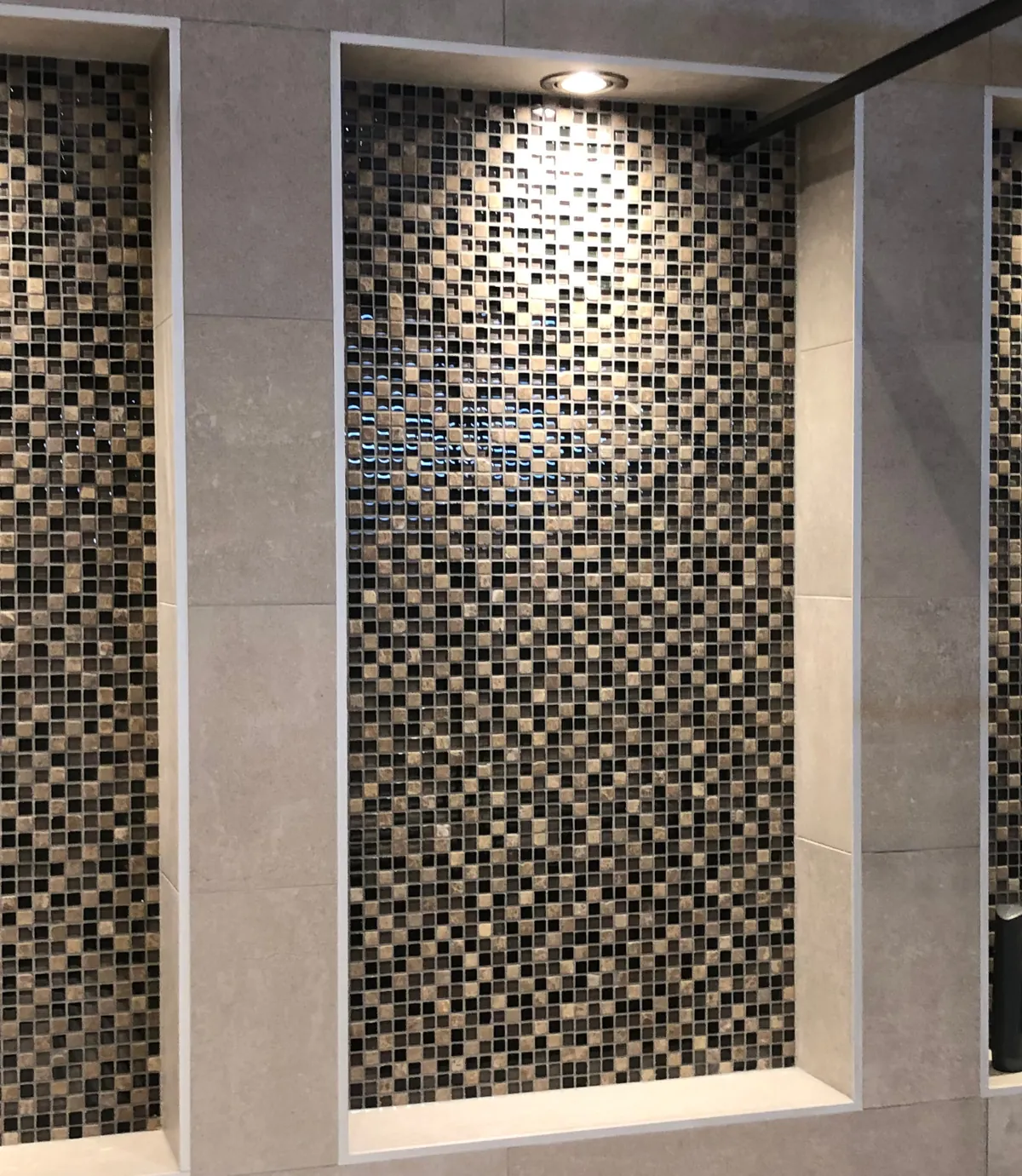 Badkamer in Barendrecht met drie verlichte mozaïeknissen en een douche met zwart profiel