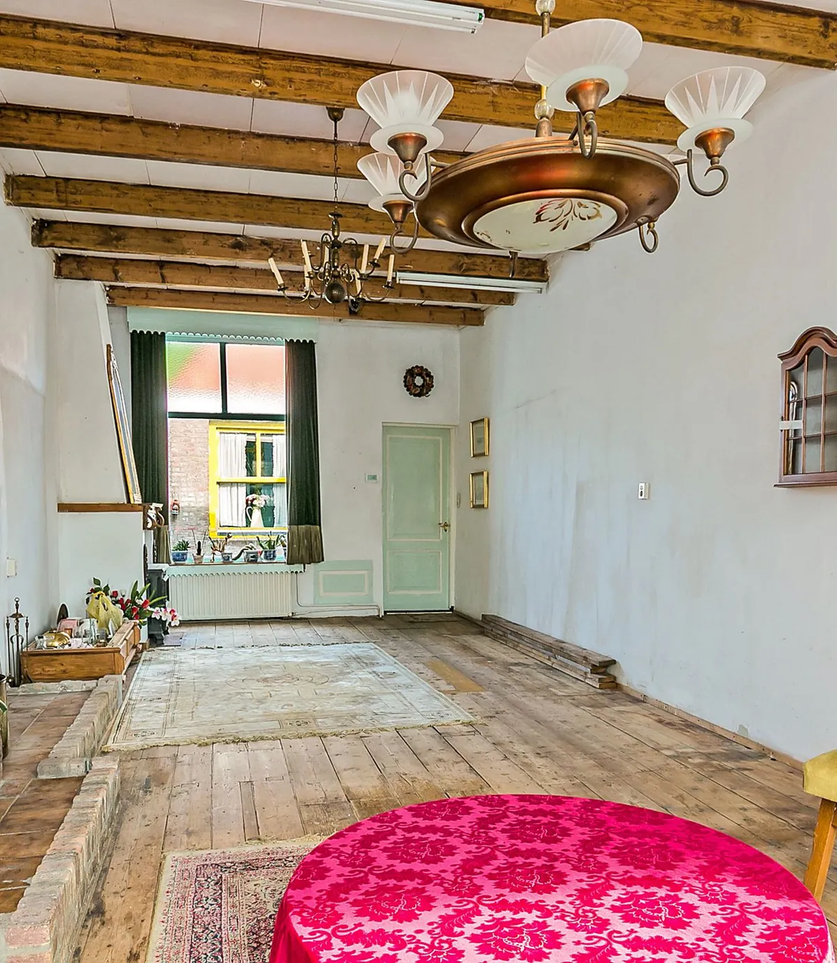 Woonkamer in Hellevoetsluis met zichtbare houten balken en een bakstenen wand